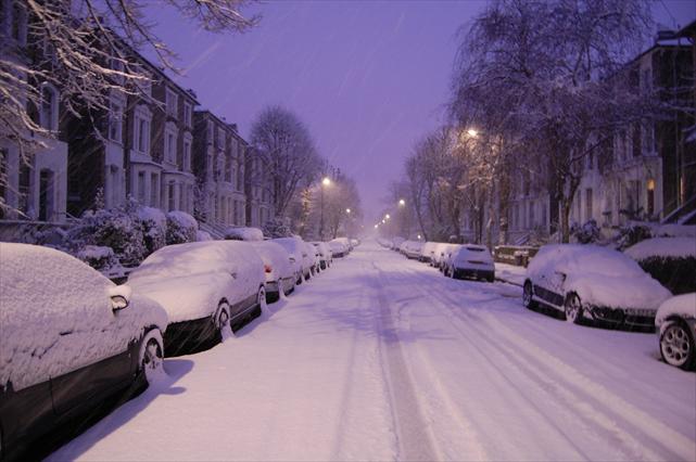 A snow covered London street on a snowy day.